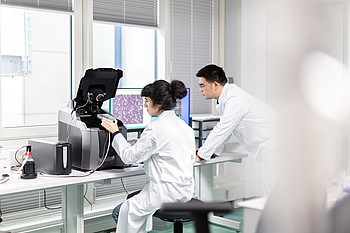 This image shows the Keyence BZ-X800 fluorescence microscope equipped with an environmental control chamber (Oko Lab) for stable long-term live-cell imaging.