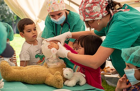 Das Foto zeigt die Teddydocs bei einem Eingriff am OP-Teddy Bruno, mit Unterstützung von mehreren Kindern in OP-Kleidung.