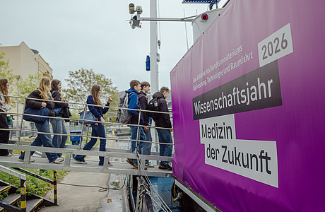 Das Foto zeigt Menschen, die über einen Steg das Ausstellungsboot MS Wissenschaft betreten